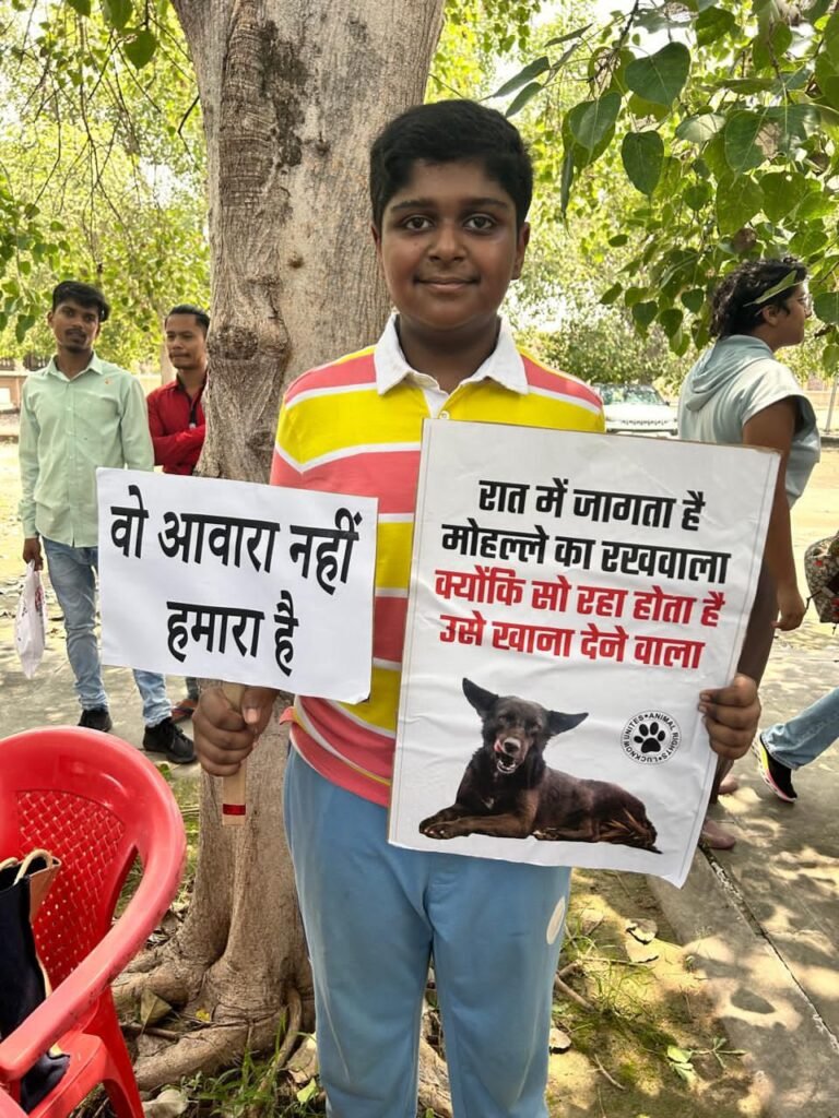 A boy holds a hand-lettered placard with a drawing of a dog.